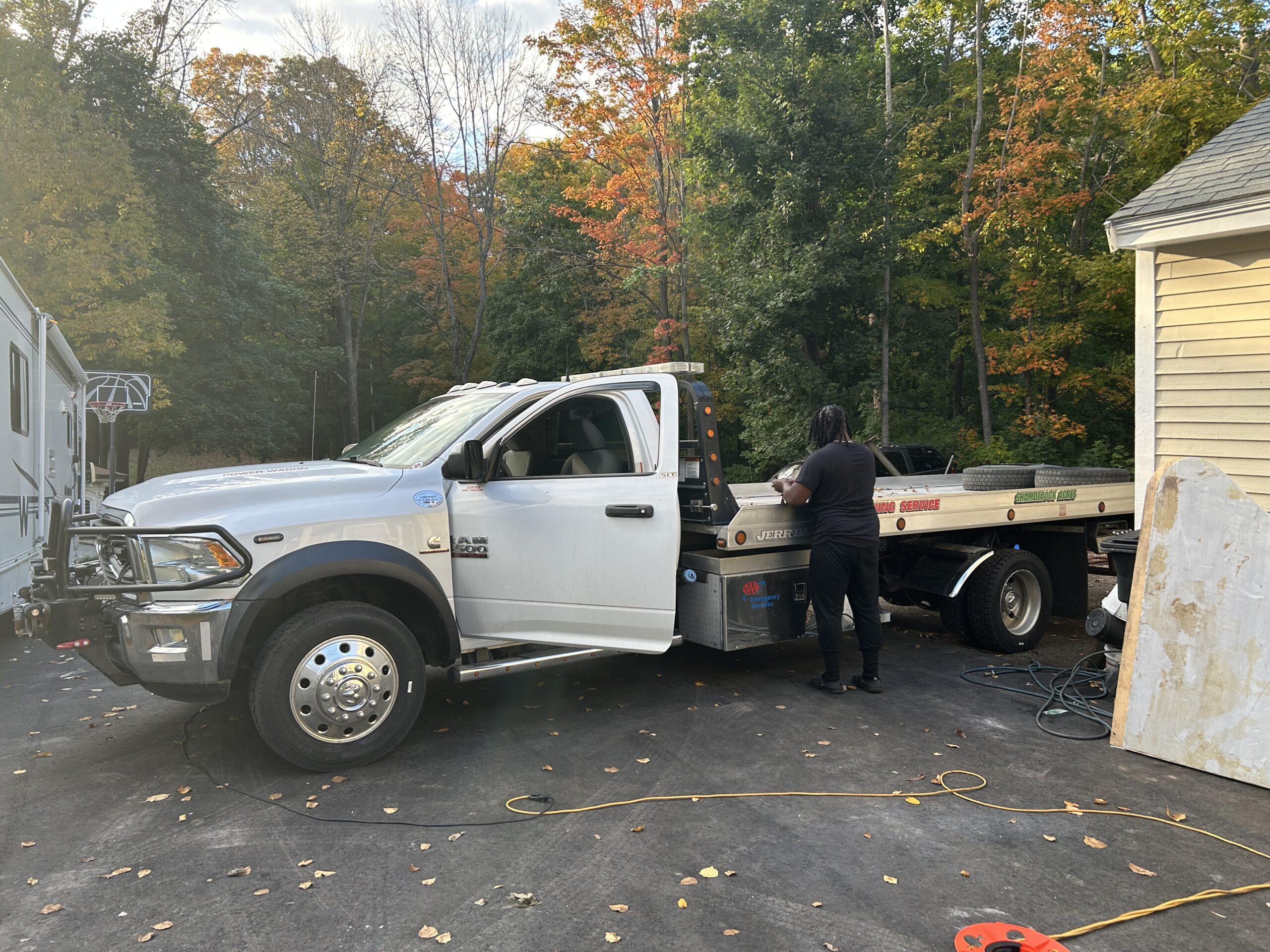 J & N Towing and Recovery photo - man with white tow truck by a yellow building | Black Owned Maine Portland